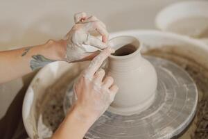 proche en haut de mains de professionnel potier moulage pot forme sur poterie roue. céramique art concept photo