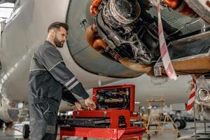 barbu homme avion mécanicien en utilisant instrument boîte dans hangar photo