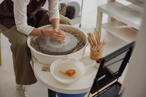 proche en haut de mains de professionnel potier moulage pot forme sur poterie roue. céramique art concept photo