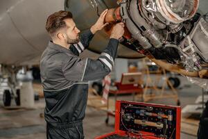 Masculin Compagnie aérienne mécanicien réparer avion dans hangar photo