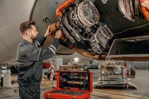 Masculin aviation mécanicien réparer avion dans hangar photo