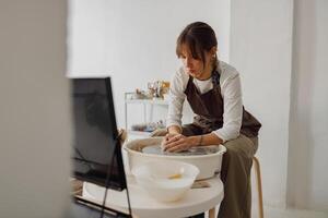 professionnel femelle artisan façonner argile bol dans poterie studio. céramique art concept photo