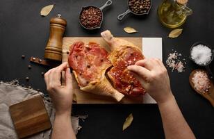 le processus de cuisine poulet pilons avec épices sur une noir table photo