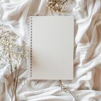 ai généré Vide blanc couverture carnet avec sec fleur sur blanc tissu maquette photo