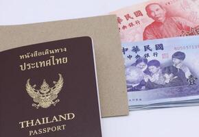 thaïlandais passeport avec Taïwan dollars billets de banque isolé sur blanc Contexte. photo