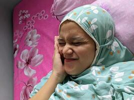 Djakarta, Indonésie. décembre 21, 2023. une femme portant une hijab est mensonge sur une lit photo
