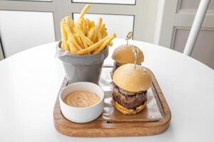 beed curseurs avec français frites et mayo tremper servi dans une plat isolé sur gris Contexte Haut vue photo