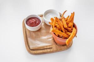 sucré Patate frites avec mayo plonger, tomate sauce servi dans plat isolé sur gris Contexte côté vue photo