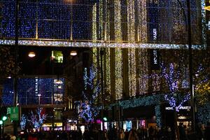 ville rue orné avec scintillement bleu vacances lumières à nuit, création une de fête atmosphère. photo