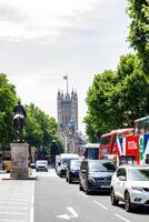 ensoleillé journée sur une animé ville rue avec voitures, une autobus à impériale bus, et une historique la tour dans le Contexte. photo