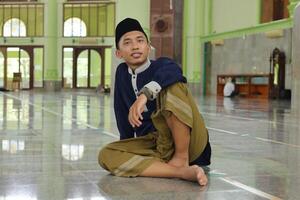 portrait de religieux asiatique homme dans musulman chemise séance dans mosquée photo