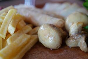 proche en haut coup de une plat avec français frites et champignons sur une assiette photo