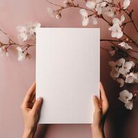 ai généré maquette, femelle mains en portant une blanc Vide feuille de papier. rose Contexte avec Sakura fleurs photo