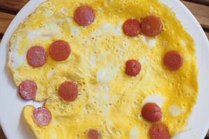 Oeuf omelette avec saucisse sur table photo