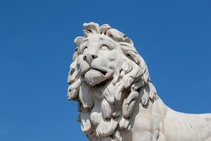 marbre Lion statue contre une clair bleu ciel, mettant en valeur complexe détails et artisanat. photo