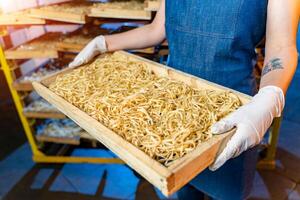 Pâtes production à plante. en bois des boites pour macaroni repos. technologique production usine industriel travail, brut macaroni fermer. photo
