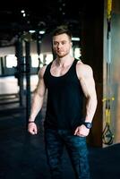 Jeune athlétique homme dans le salle de sport. fort Gym entraîneur debout. photo