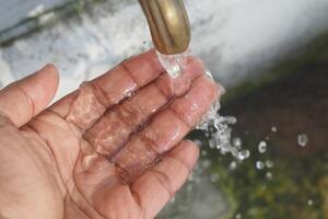 main en dessous de robinet, l'eau écoulement, les doigts diffuser, la lessive en dessous de robinet photo