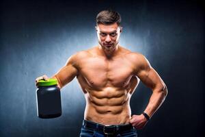 Masculin athlète bodybuilder avec une nu torse détient une pot de des sports nutrition dans le sien mains et pose sur une bleu Contexte. photo