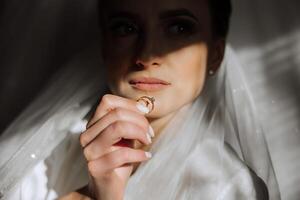 fermer de un élégant diamant bague sur une femme doigt avec une moderne manucure, lumière du soleil. l'amour et mariage concept. doux et sélectif se concentrer. photo