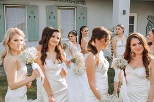 mariage la photographie. demoiselles d'honneur dans beige Robes marcher avec bouquets de gypsophile photo