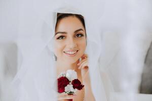 mariage boutonnière de fleurs dans le mains de le la mariée. mariage détails. le premier réunion de le la mariée et jeune marié. le la mariée est attendre pour le jeune marié. portrait de le la mariée. photo