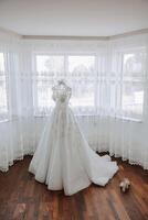 chambre intérieur avec mariage robe préparé pour le cérémonie. une magnifique luxuriant mariage robe sur une mannequin dans une Hôtel chambre. photo