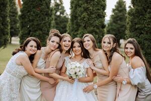 mariage la photographie. une brunette la mariée dans une blanc robe avec une bouquet et sa brunette copines photo