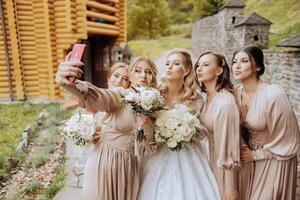 mariage la photographie. une blond la mariée dans une blanc robe détient une bouquet et prend une selfie photo