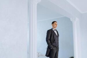 portrait de souriant réussi caucasien homme dans formel costume, posant dans chambre, content Jeune Masculin patron ou PDG à la recherche à caméra, montrant confiance et force, direction concept photo