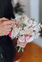 jeune marié avec une bouquet de des roses, jeune marié avec bouquet, jeune marié avec une mariage bouquet, une Jeune homme avec une mariage bouquet sur le sien main, bien adapté homme photo