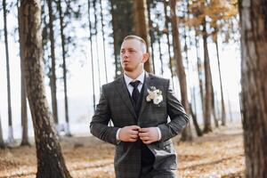 portrait de une Beau Jeune jeune marié sur un l'automne journée en plein air dans un élégant costume. Extérieur photo. Beau homme dans une affaires costume. photo