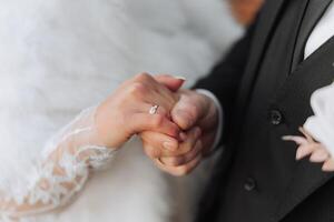 une Jeune la mariée et jeune marié tendrement embrasse dans le des rayons de le l'automne Soleil. soumissionner et magnifique Jeune fille la mariée. une homme baisers le sien bien-aimé. contre le Contexte de une magnifique jardin photo