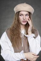 magnifique fille avec longue cheveux dans une beige béret sur une gris Contexte. photo