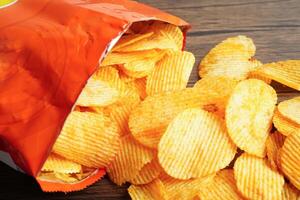 croustilles de pommes de terre dans un sac ouvert, délicieux assaisonnement pour barbecue épicé pour les frites, collations frites en tranches fines de restauration rapide. photo