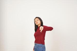 Jeune asiatique femme dans rouge T-shirt montrant pouce bas, être en désaccord concept isolé sur blanc Contexte photo