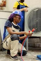 proche en haut de africain américain ingénieur en portant collecteur jauges utilisé pour vérification air Conditionneur fréon les niveaux. bipoc technicien en utilisant baromètre, vérification réfrigérant les niveaux de HVAC système photo