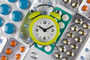 du quotidien médicament prise routine concept photo avec pilules et une l'horloge