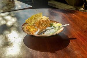 une assiette de est Javanais madun pecel riz sur une en bois table dans le Matin lumière du soleil photo