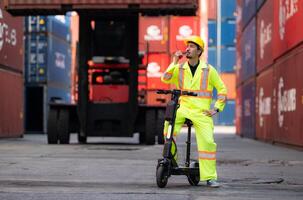 portrait de une entrepôt ouvrier Parlant sur une walkie talkie avec une collaborateur dans un vide récipient entrepôt tandis que conduite une scooter à inspecter travail photo