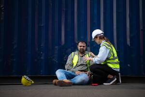 une gars ouvrier a été impliqué dans une jambe accident dans une récipient espace de rangement cour. une collègue a été en utilisant le walkie talkie à demande immédiat aide. photo