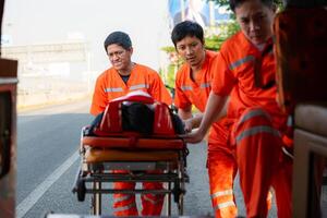 le paramédical est assistant un blessé homme dans un urgence situation sur le route. photo