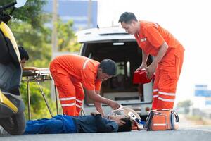 le paramédical est assistant un blessé homme dans un urgence situation sur le route. photo