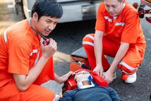 le paramédical est assistant un blessé homme dans un urgence situation sur le route. photo