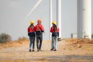 équipe de ingénieurs travail sur vent turbines dans une vent ferme photo