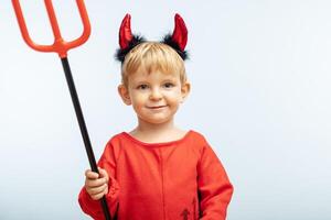 content de bonne humeur garçon dans diable costume avec trident sur bleu Contexte photo