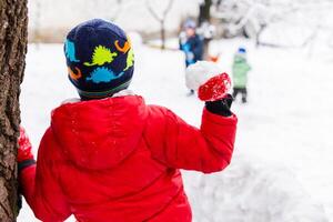 peu les enfants en jouant avec boules de neige Extérieur dans le parc photo