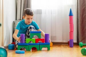 mignonne peu enfant en jouant avec coloré Plastique jouets ou blocs photo