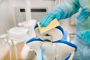 une infirmière désinfecte travail surfaces dans le dentiste bureau. photo