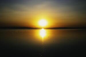 le coucher du soleil plus de le lac. Soleil et réflexion sur le lac. la nature ou environnement photo